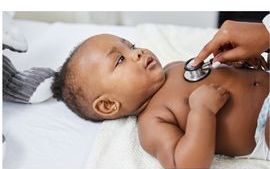 Baby laying on back being examined with stethoscope