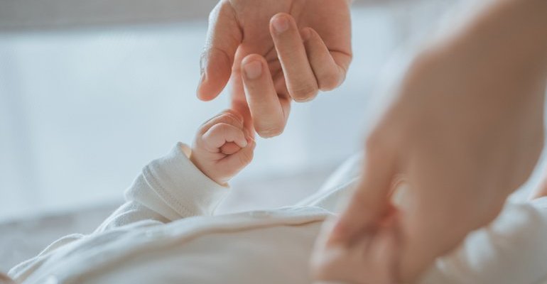 Person holding a baby's hands