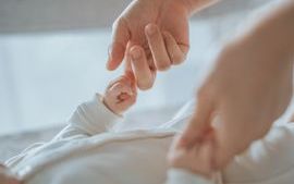 Person holding a baby's hands